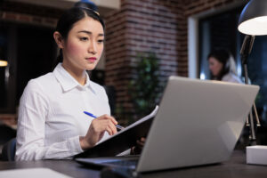 Compliance manager reviewing sanctions screening documentation and APTCP requirements for Japanese financial institutions