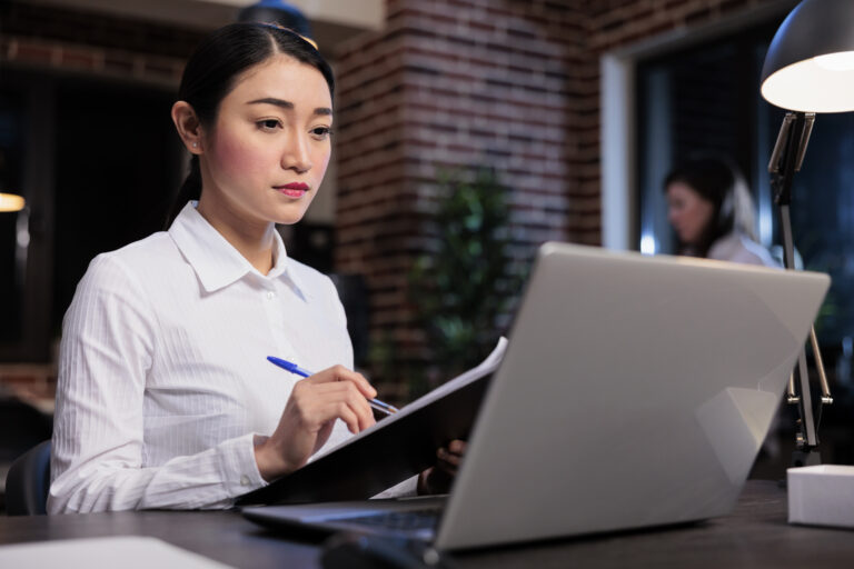 Compliance manager reviewing sanctions screening documentation and APTCP requirements for Japanese financial institutions