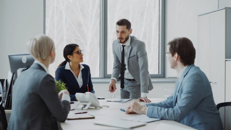 Compliance professionals in a boardroom meeting reviewing documents during an AML culture programme assessment