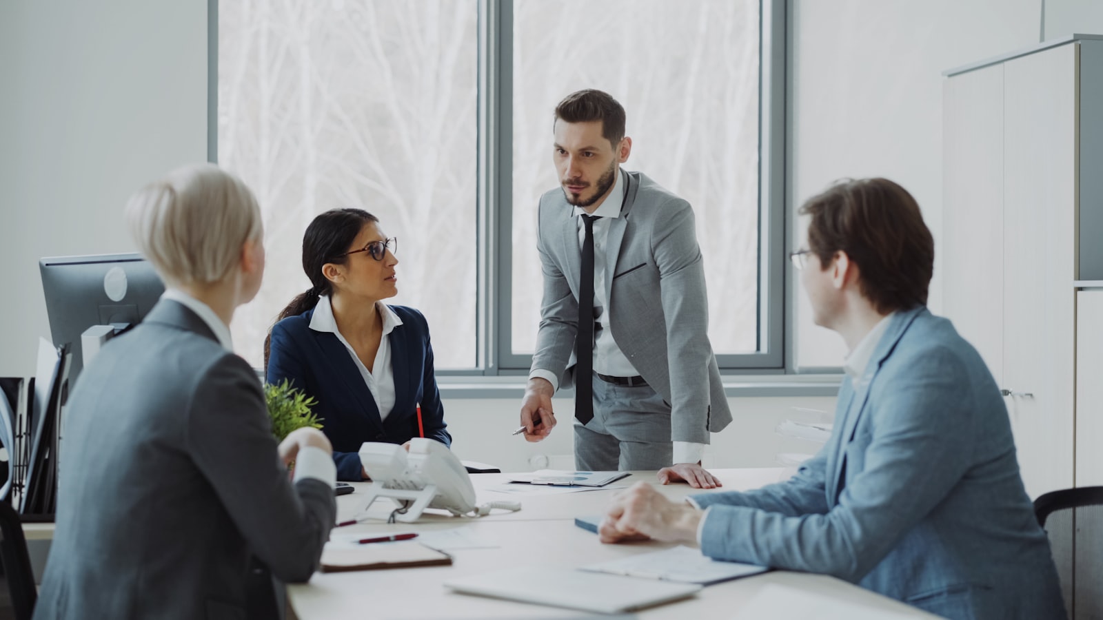 Compliance professionals in a boardroom meeting reviewing documents during an AML culture programme assessment
