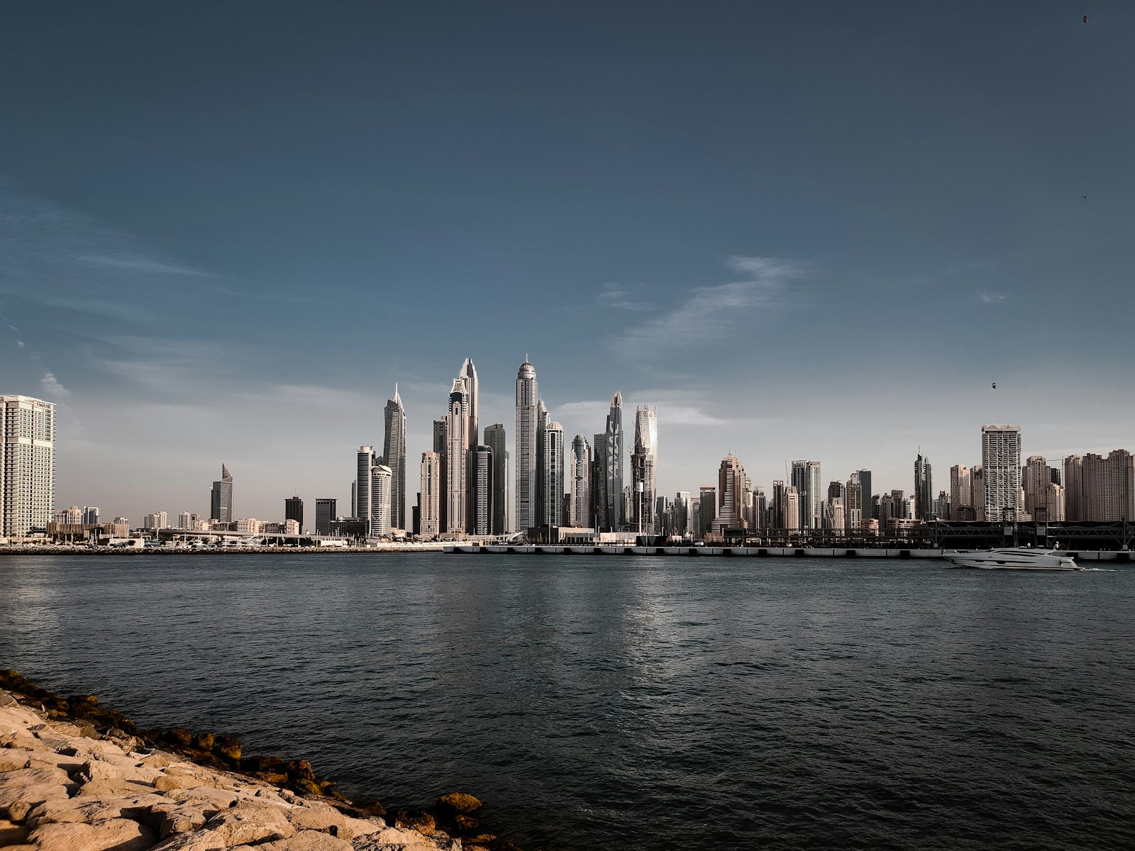 Dubai skyline across the waterfront representing the three distinct AML regulatory environments of DIFC, ADGM and mainland UAE