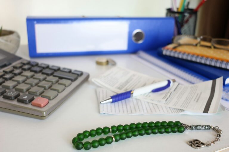 Professional workspace with documents and calculator representing tax compliance and financial reporting obligations for Gulf financial institutions under FATCA and CRS frameworks
