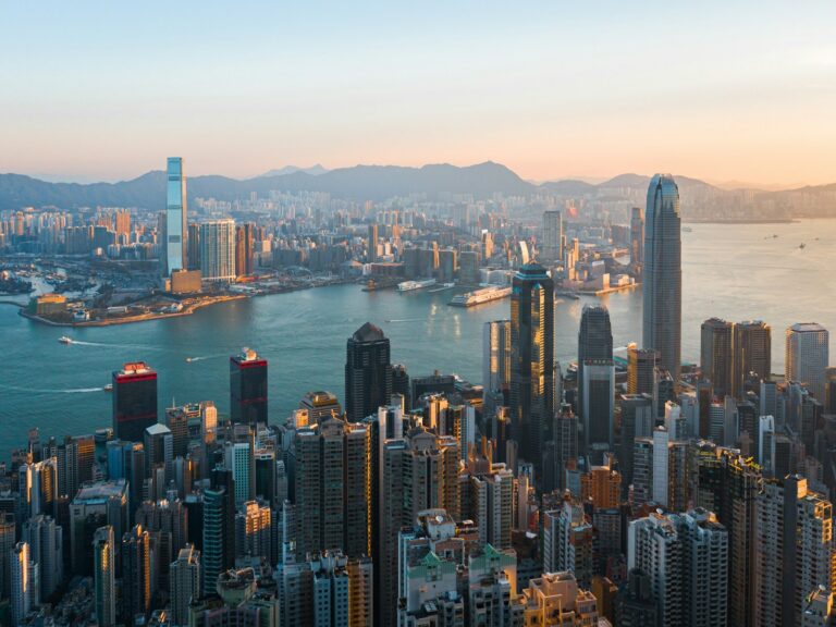 Aerial view of the Hong Kong skyline across Victoria Harbour with IFC and ICC towers, representing the regulatory environment for AMLO AML/CFT compliance