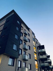Low-angle view of a modern residential apartment building, representing high-risk property transactions subject to AML and DNFBP obligations
