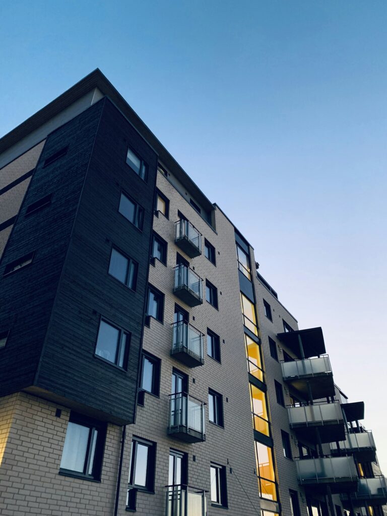 Low-angle view of a modern residential apartment building, representing high-risk property transactions subject to AML and DNFBP obligations
